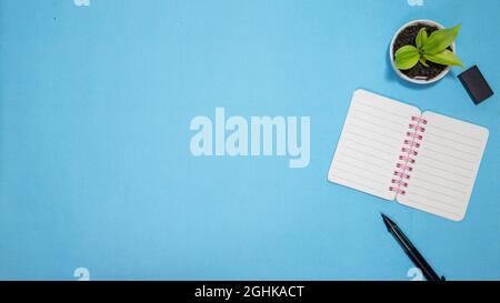 Education or back to school Concept. Top view of Colorful school supplies with books, color pencils, calculator, pen cutter clips and apple on blue Stock Photo