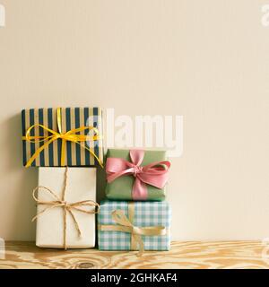 Stack of gift boxes on wooden table. beige wall background Stock Photo