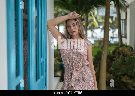 Portrait of attractive caucasian woman with blond long hair wearing casual dress, looks directly at camera. Face expressions concept. Stock Photo