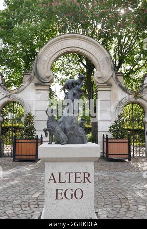 The sculpture 'Alter Ego' by sculptor Arnaud Kasper and the stone entrance designed by Art Nouveau architect Eugene Petit at the âÂ€Â˜Cimetiere des ChiensâÂ€Â™ in Asnieres-sur-Seine on the outskirts of Paris, France on May 2021.The Parisian âÂ€Â˜Cemetery of Dogs and Other Domestic AnimalsâÂ€Â™ is said to be the world's oldest public pet cemetery. Le âÂ€Â˜Cimetiere des ChiensâÂ€Â™ is a long, narrow cemetery with attractively landscaped grounds that overlook the Seine. The neatly laid-out rows of graves include tombstones and other monuments from the late 19th Century to the present day, many wi Stock Photo