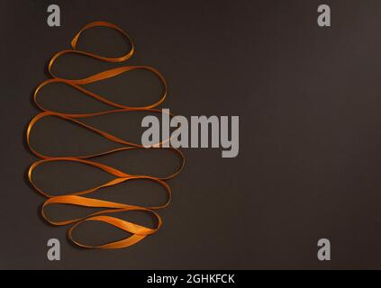 Close up Easter egg made of yellow ribbon on black background. Trendy Easter composition. Copy space for text. Minimal Easter concept. Stock Photo