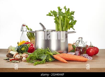 Healthy food still life with assorted fresh organic vegetables arranged around a stainless steel pot ready for making a vegetarian or vegan stew or so Stock Photo