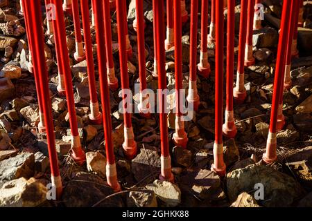 Red pipes in gravel surface. Stock Photo