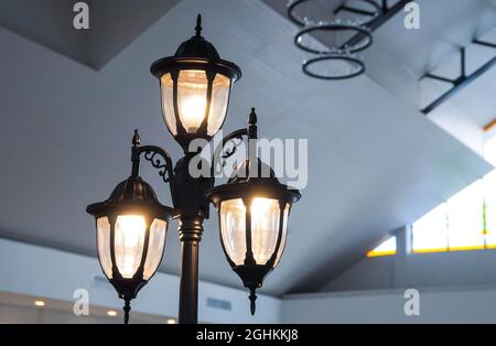 Old style street lamp installed indoor room in selective focus Stock Photo