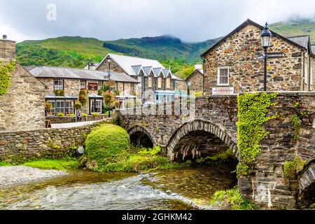 Slate cottages, bridge and the Colwyn River in the charming village of Beddgelert, Snowdonia, Wales, UK Stock Photo