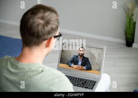 Two diverse colleagues or friends speaking through the screen, using laptop app for virtual connect, video meeting, talking about joint startup, discussing details, develop concept and strategy Stock Photo