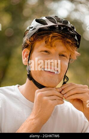 Guy putting on bicycle safety helmet Stock Photo