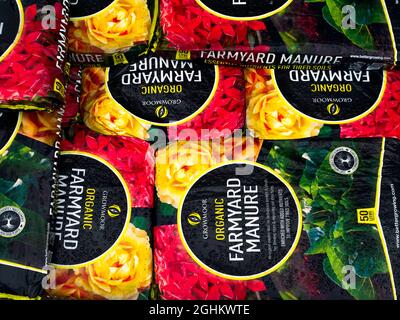 A stack of bags of Farmyard Manure  improving soil quality and promoting plant growth  for sale  in a garden centre Stock Photo