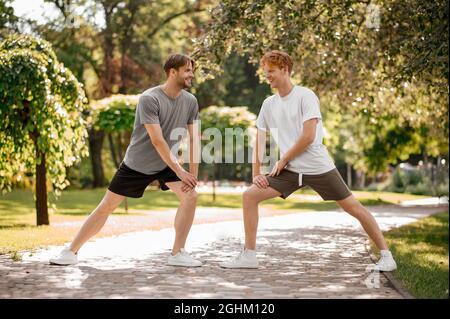 Two friends opposite each other doing stretching exercise Stock Photo