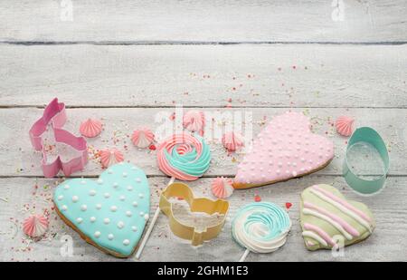 Easter cooking baking background with pastel colored easter cookies and meringue., Cookie Cutters., sugar sprinkles. Wooden rustic background, flatlay Stock Photo