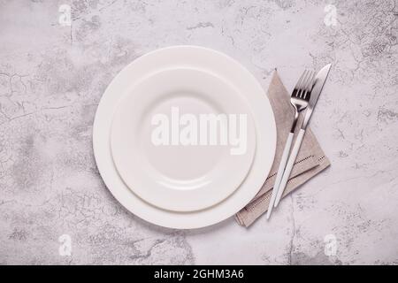 Clean empty white plate with cutlery. Copy space, mock up, top view. Concept for menu with utensil. Stock Photo