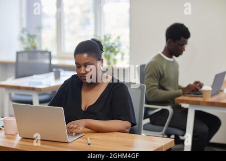 Concentarted female entrepreneur working on laptop, she is reading article or report online Stock Photo