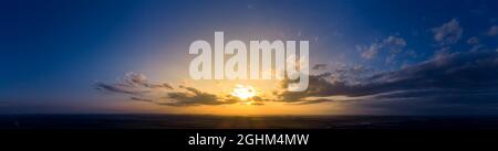 Panorama of sunrise and dark morning blue sky. Cloudy weather at dawn with bright orange sunlight Stock Photo