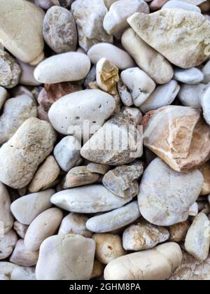 Ionian sea pebble marble stone beach close-up texture. Various rocky surface in Greece, Lefkada island coast Stock Photo