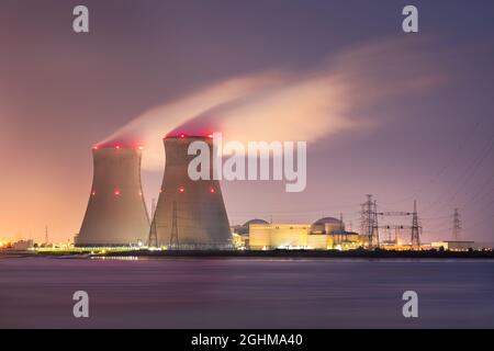 Riverbank with nuclear power plant Doel at night with large plumes of vapor, Port of Antwerp, Belgium Stock Photo