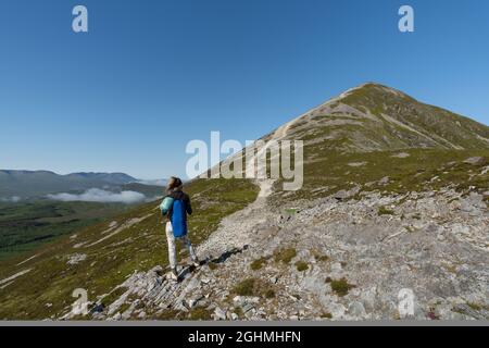 Scenic view of a young mountaineer woman climbing the Croagh Patrick mountain Stock Photo