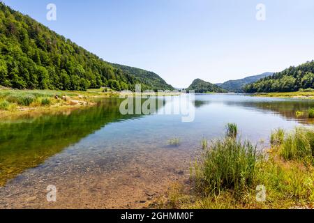 Landscape at Lake Lac de Kruth-Wildenstein in Alsace, France with blue sky, green forests and gras in summer Stock Photo
