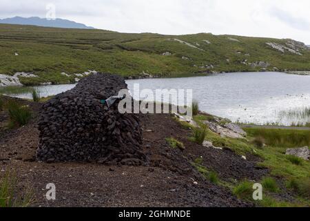 A neatly-stacked turf heap in an area of bog in County Galway Ireland Stock Photo