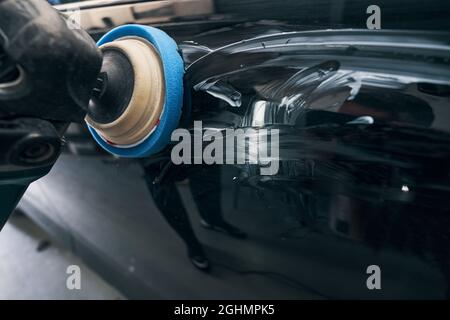 Polishing instrument with soft pad pressed to car surface Stock Photo