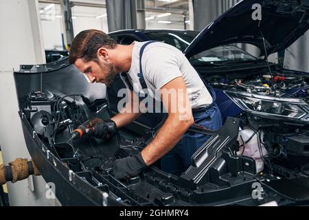 Automobile mechanic using drill on car part Stock Photo
