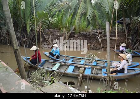 Local Vietnamese on boat awaiting tourists for mangrove forest tour in Southern Vietnam Stock Photo