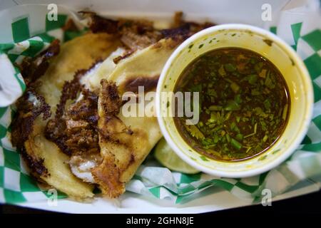 Closeup shot of birria tacos with sauce on a plate Stock Photo