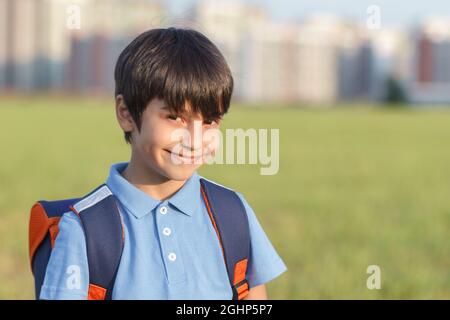 Portrait of happy boy with backpack, school child waiting for school bus, primary school student, on the way to school Stock Photo