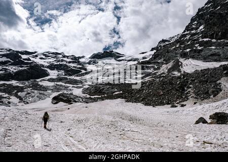 Woman with crampons and snow poles climbing a glacier in Mount Rosa range, Italian Alps Stock Photo
