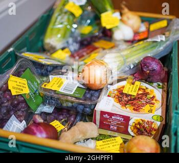 Thrifty shopping. Saving money. Groceries/ food products with yellow, reduced stickers. Almost out of date/ past sell-by dates. UK poverty/ food crisis. Stock Photo