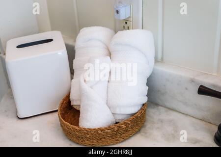 https://l450v.alamy.com/450v/2ghr8jj/a-basket-of-organized-clean-rolled-white-towels-on-a-bathroom-counter-in-a-guest-bathroom-2ghr8jj.jpg