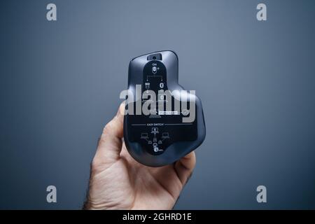 POV male hand holding new Logitech MX Master 3 wireless mouse with hyper-fast scroll Stock Photo