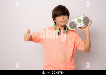 Young boy holding a radio cassette isolated over white background. Stock Photo