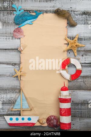 Cute set of kids handcrafted boats, fish, nautical attributes and more on rough vintage wooden background and with blank papyrus blank top view Stock Photo