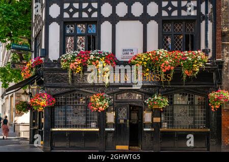 LONDON - SEPTEMBER 07, 2021: The oldest pub in Mayfair, The Coach and Horses Public House, established in 1744, is decorated with hanging baskets full Stock Photo
