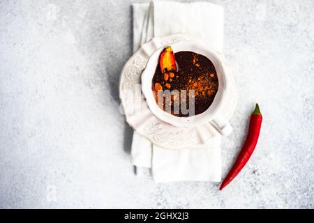 Overhead view of a cup of hot chilli chocolate with fresh chillis Stock Photo
