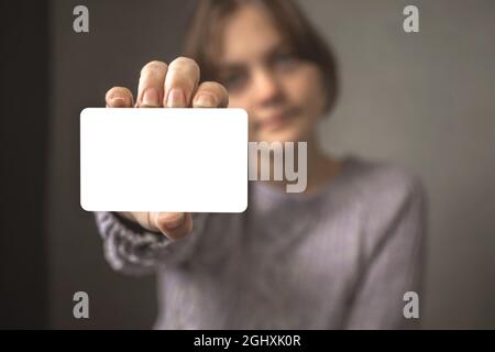 Businesswoman holding paper card mockup in her hands. Black white credit card template in hands, copy space Stock Photo