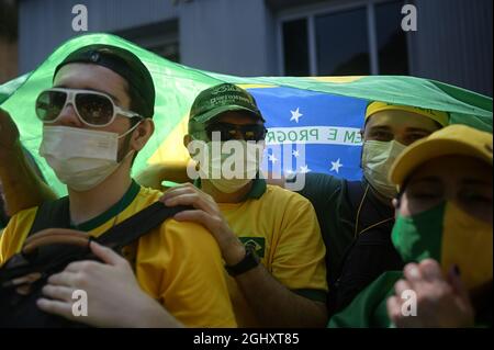 Sao Paulo, Brazil. 07th Sep, 2021. Supporters of President Bolsonaro stand under a Brazilian flag as they wait for the head of state to appear on Independence Day. Tens of thousands of people have demonstrated for Bolsonaro with anti-democratic slogans. The right-wing leader himself threatened the Supreme Court STF during a speech in Brasilia. Credit: Andre Borges/dpa/Alamy Live News Stock Photo