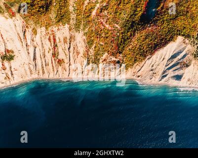 Aerial view of rocky shore with cliff and blue sea in autumn Stock Photo