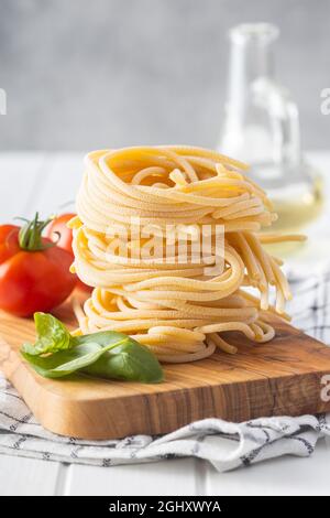 Italian pasta nest. Uncooked spaghetti nest on cutting board. Stock Photo
