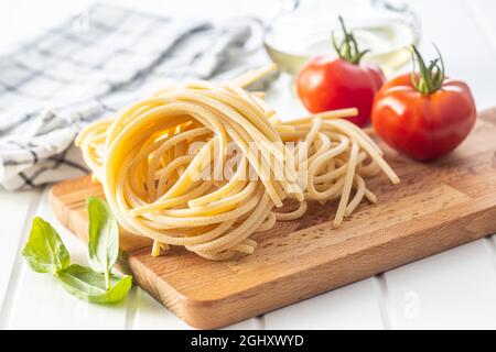 Italian pasta nest. Uncooked spaghetti nest on cutting board. Stock Photo