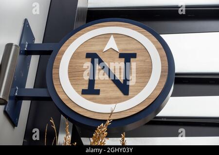 Low angle view of a large N on a sign, pointing north in a large outdoor shopping district. Stock Photo