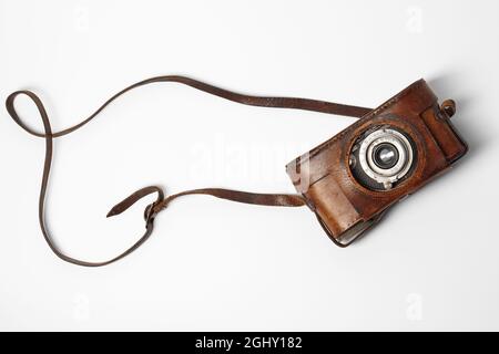 Old vintage camera with 35mm lens in brown leather case isolated on white background Stock Photo