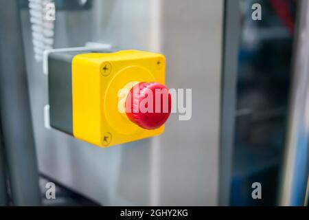 Close up view: machine control panel with red switch button - emergency stop Stock Photo