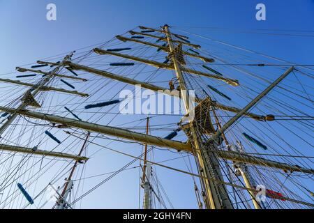 large sailing ship masts with many ropes on a blue sky background Stock Photo