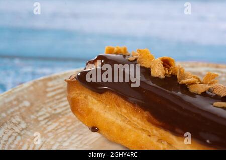 Chocolate eclair with coffee beans on light blue background isolated Stock Photo