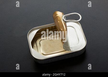 Empty square tin can for food with open lid and ring pull on black background. Top view photo. Stock Photo