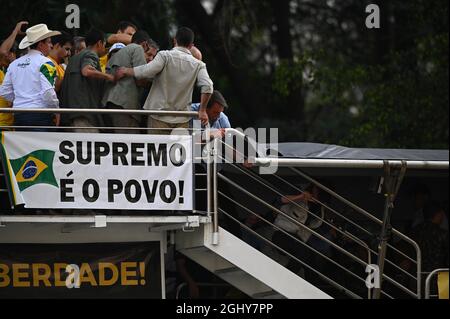 Sao Paulo, Brazil. 07th Sep, 2021. Jair Bolsonaro (r), president of Brazil, bends down in front of a staircase after speaking to numerous supporters on Independence Day. 'The authorities are subject to the people,' reads a placard alluding to the conflict between Bolsonaro and the Supreme Court. Credit: Andre Borges/dpa/Alamy Live News Stock Photo