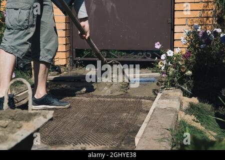 Cementing garden paths on top of metal mesh, construction work in the garden. Stock Photo