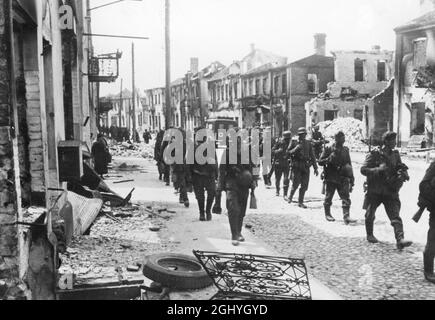 A detachment of German infantry marches through a destroyed town on the Eastern Front. Stock Photo