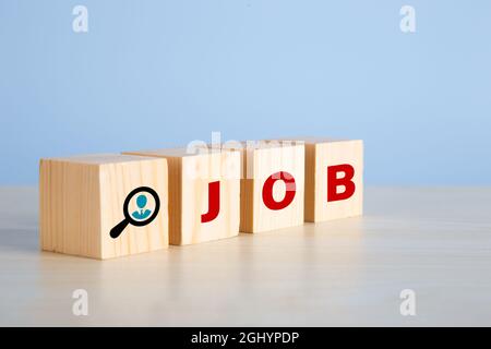 The word job on wooden cubes with on blue background. Searching for a job, employment, recruitment or career in business concept. Stock Photo